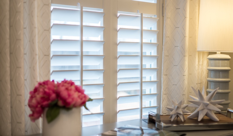 Plantation shutters by flowers in San Diego